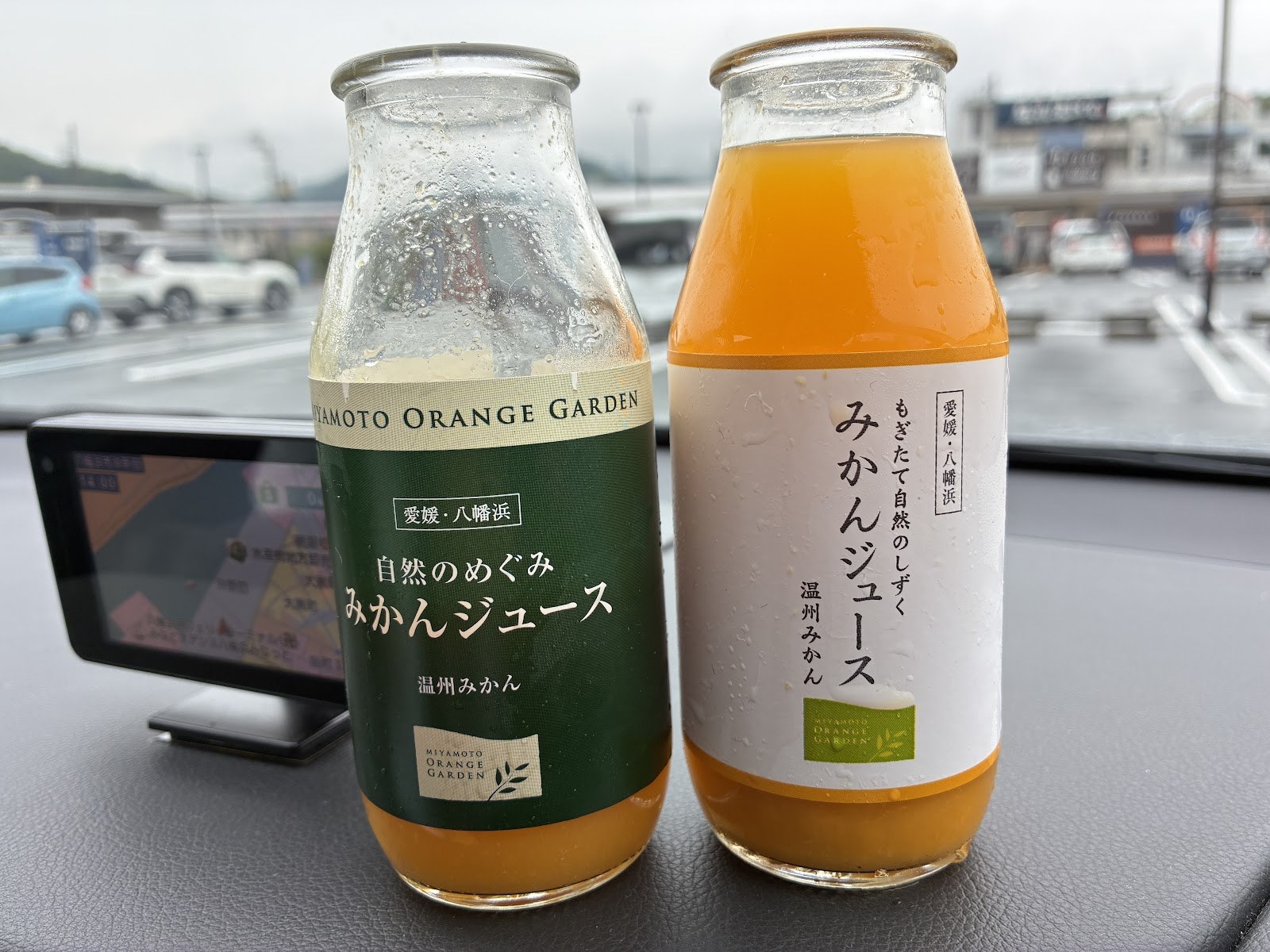 ダッシュボードに置かれたみかんジュースの瓶2本