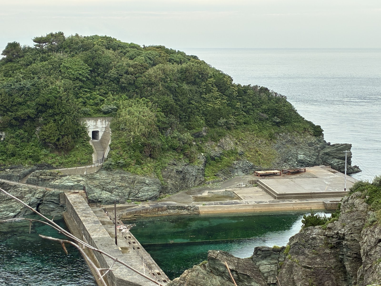岬の突端と、海に突き出た岩、白い建物