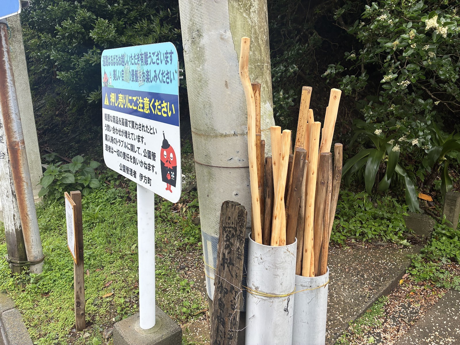 看板の下に立てられた竹の杖が数本