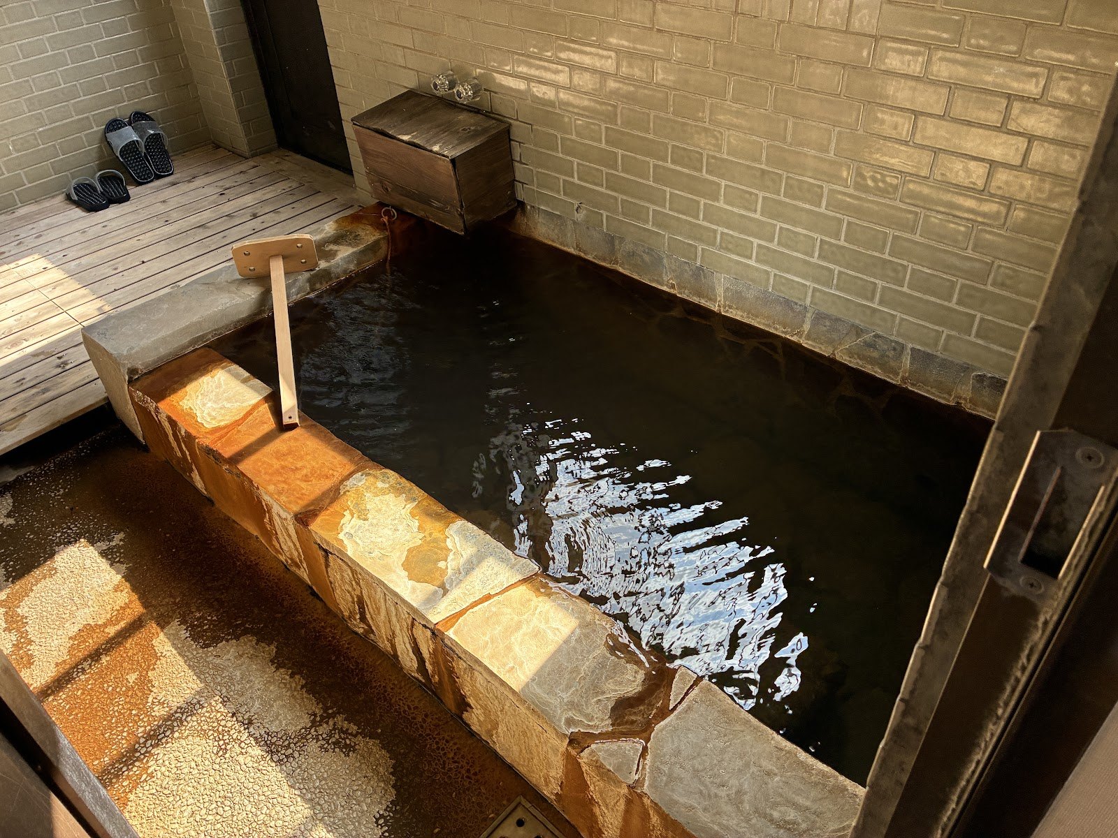 石を敷いた内湯。木の湯枕と桶が置かれている