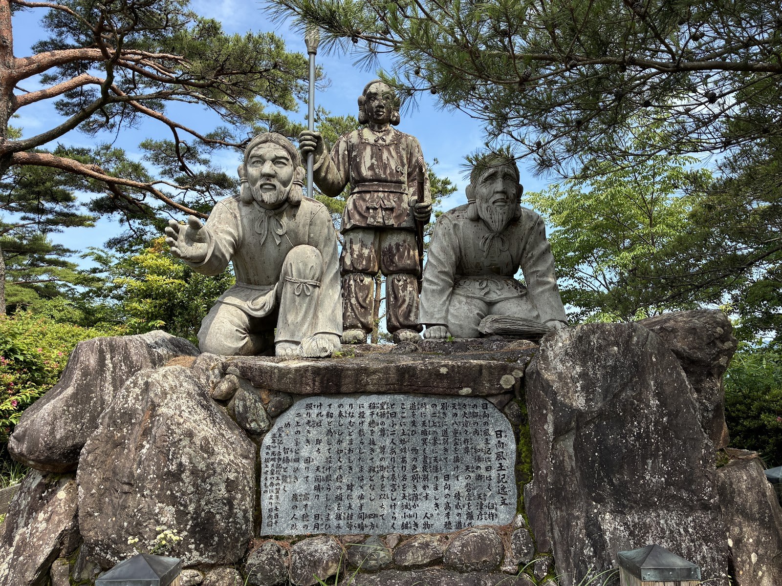 岩の上に置かれた三体の石像と碑文