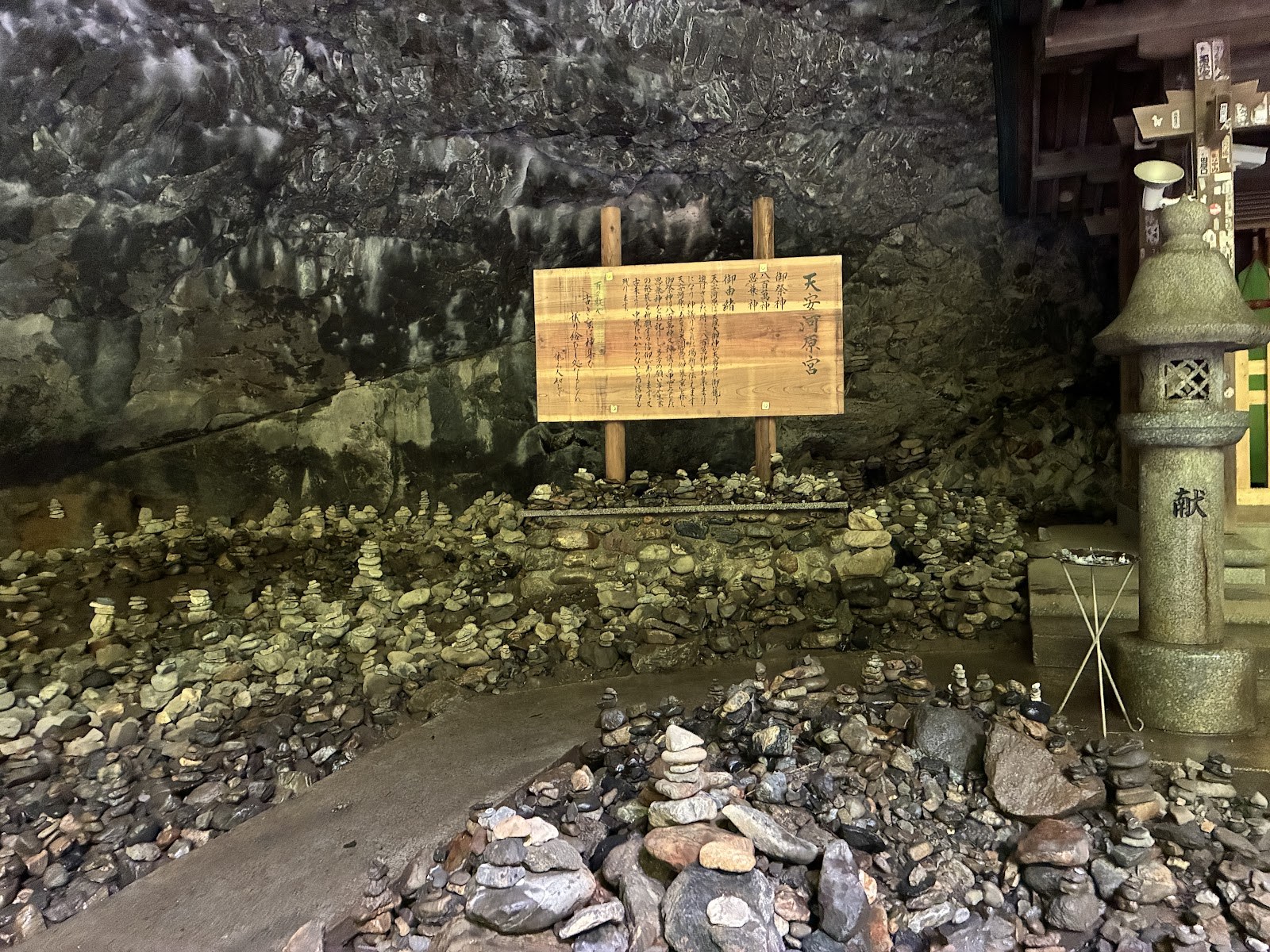天安河原の奥にある解説板と石灯籠、積まれた石