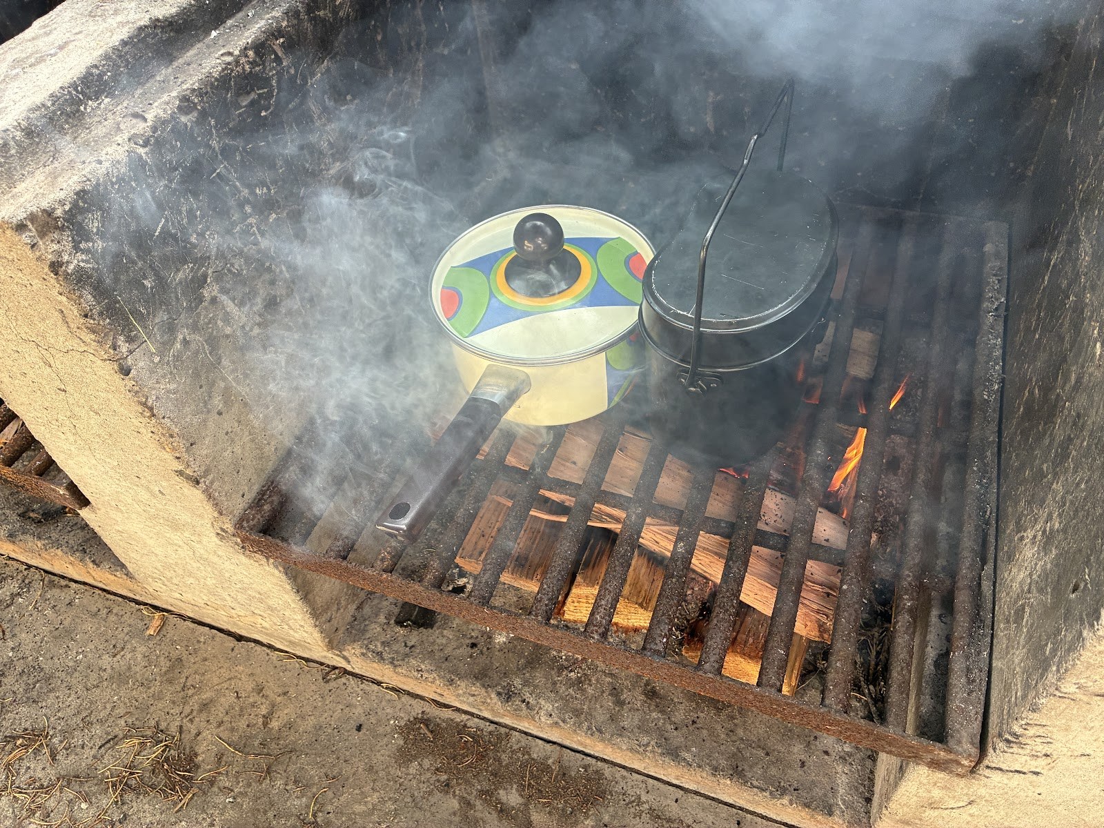かまどの上にかけられた羽釜と鍋、立ちのぼる煙