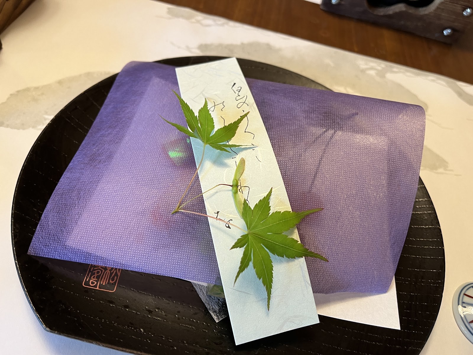 紫の懐紙と青もみじを敷いた膳に、お品書きが置かれている