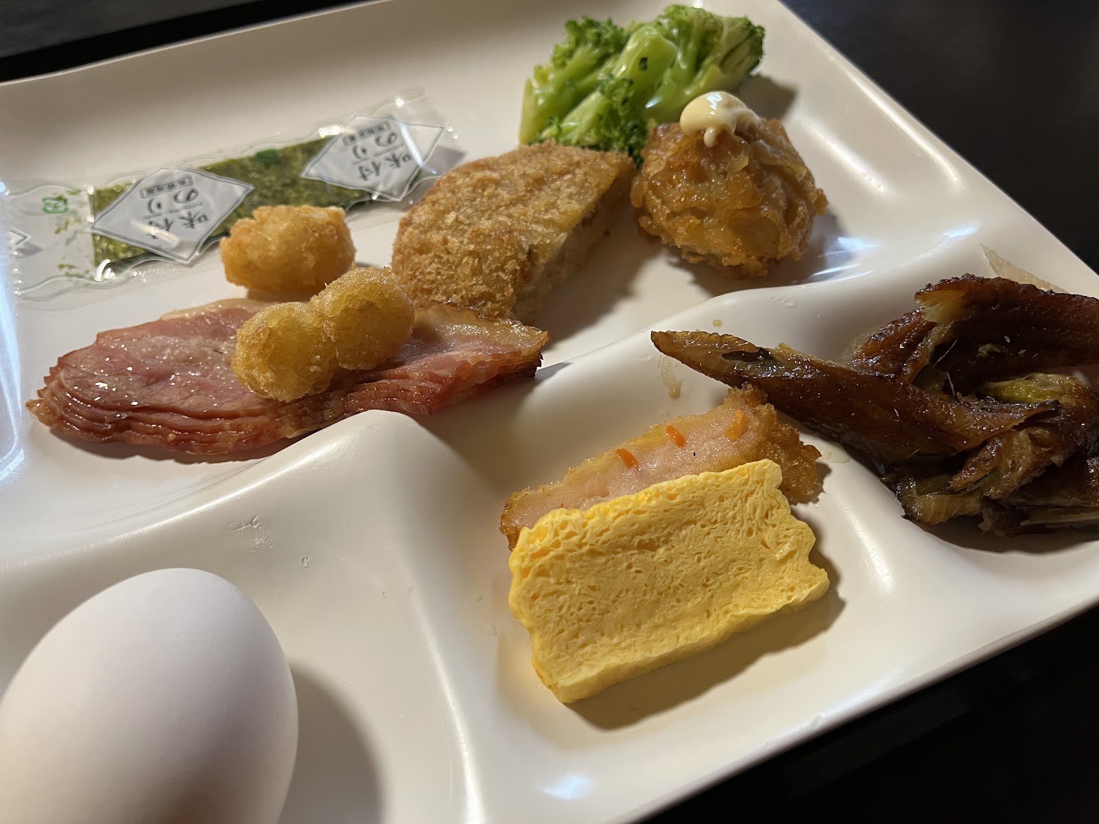 朝食のプレート。卵焼き、ゆで卵、唐揚げ、ウインナー
