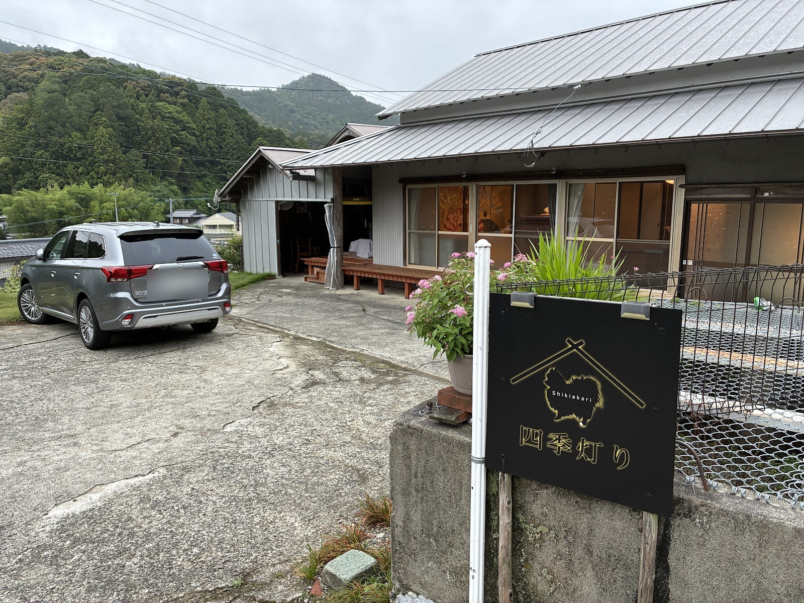 建物の前に立つ「四季灯り」の看板と駐車スペース