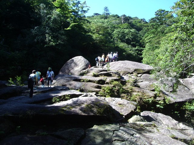 大きな一枚岩の上を歩く登山者たち