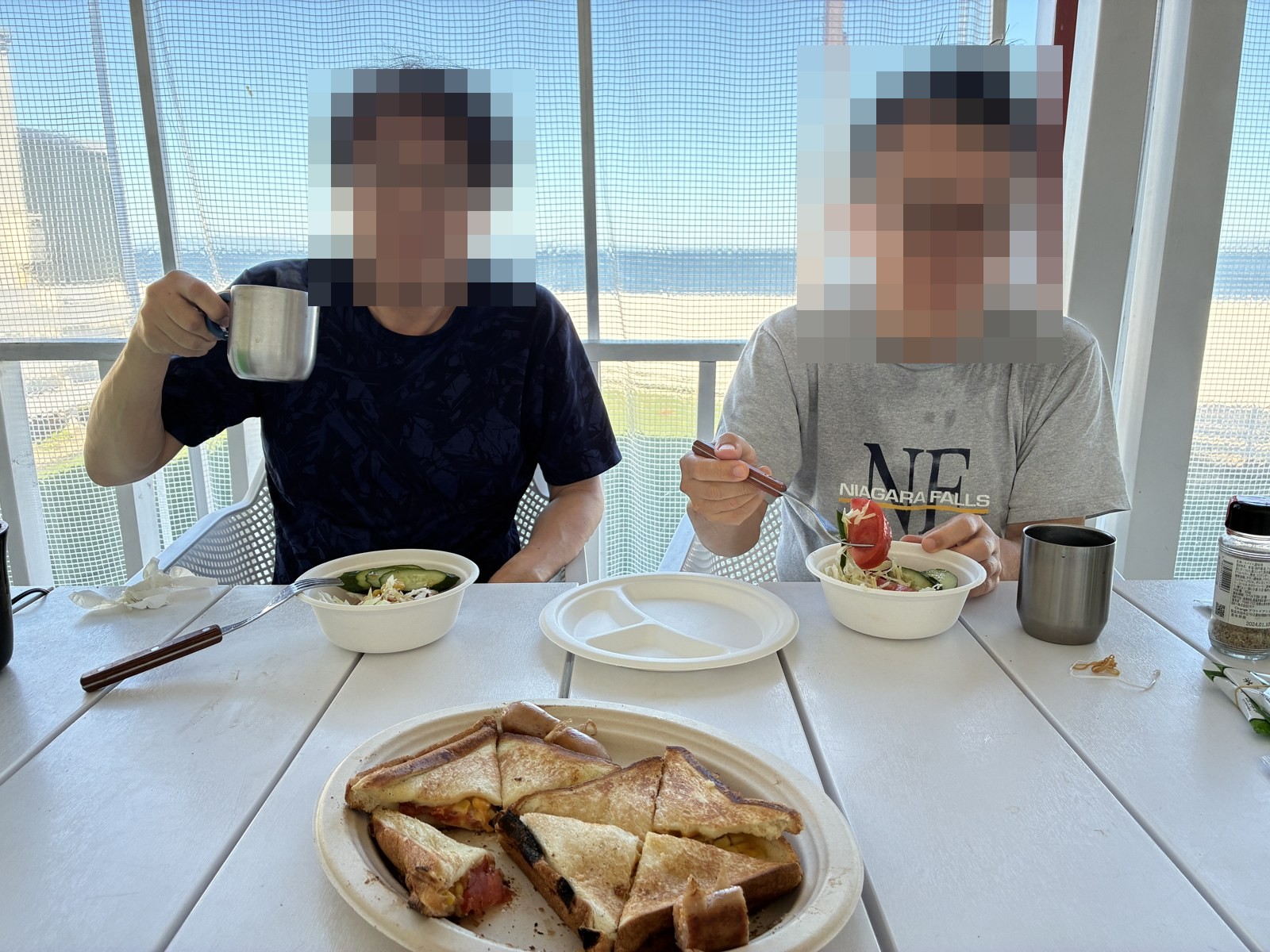 翌朝の食卓。焼き上がったホットサンドとサラダ。顔にはモザイクをかけています