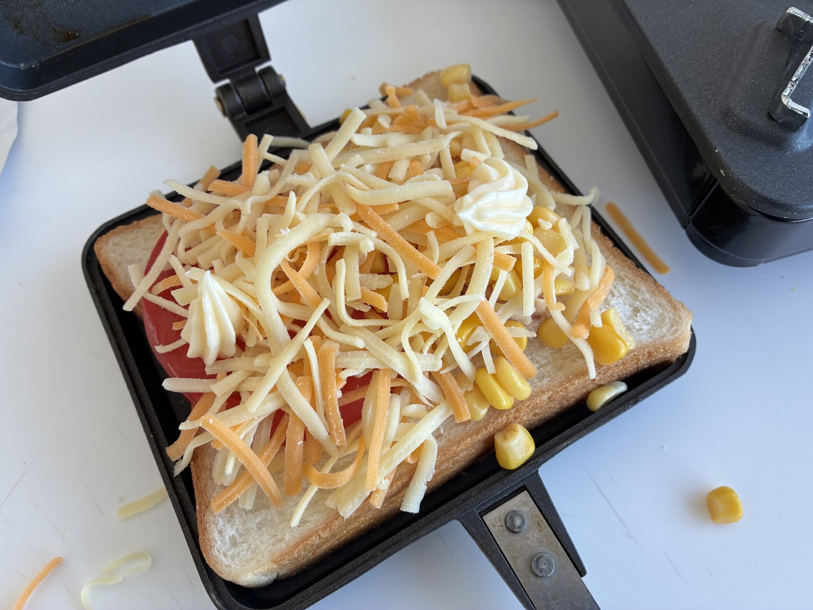 バウルーにのせた食パン、トマト、ツナ、大量のとろけるチーズとコーン