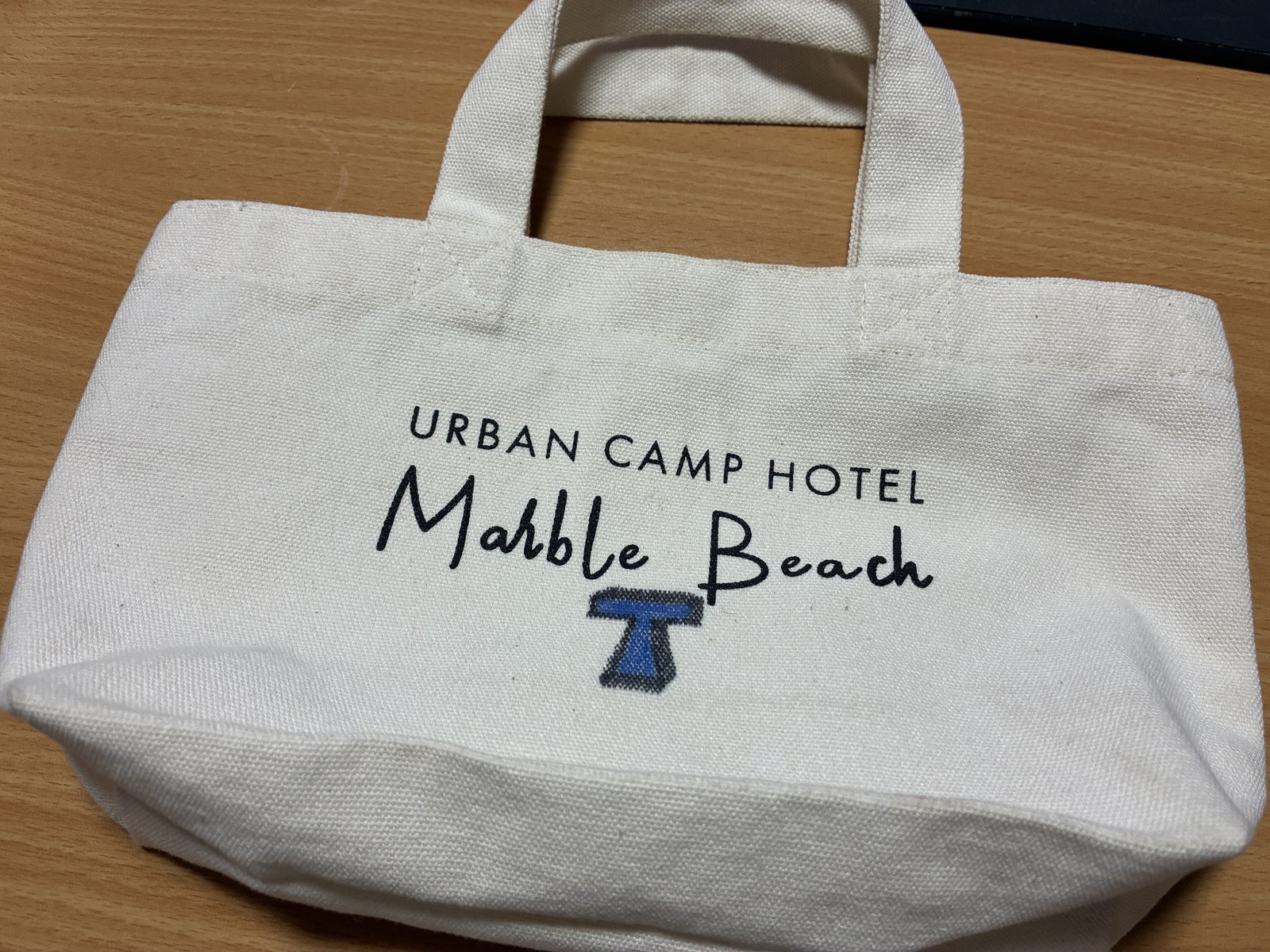 チェックインのときに渡されるトートバッグ。表に「URBAN CAMP HOTEL Marble Beach」