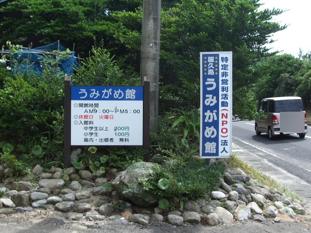 「うみがめ館」の案内看板。開館時間と入館料が書かれている