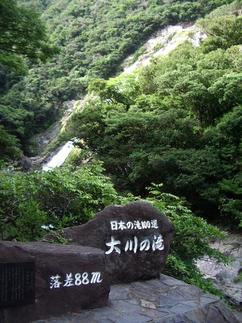 大川の滝の入口にある「日本の滝百選 大川の滝 落差88m」の石碑と、奥に落ちる滝